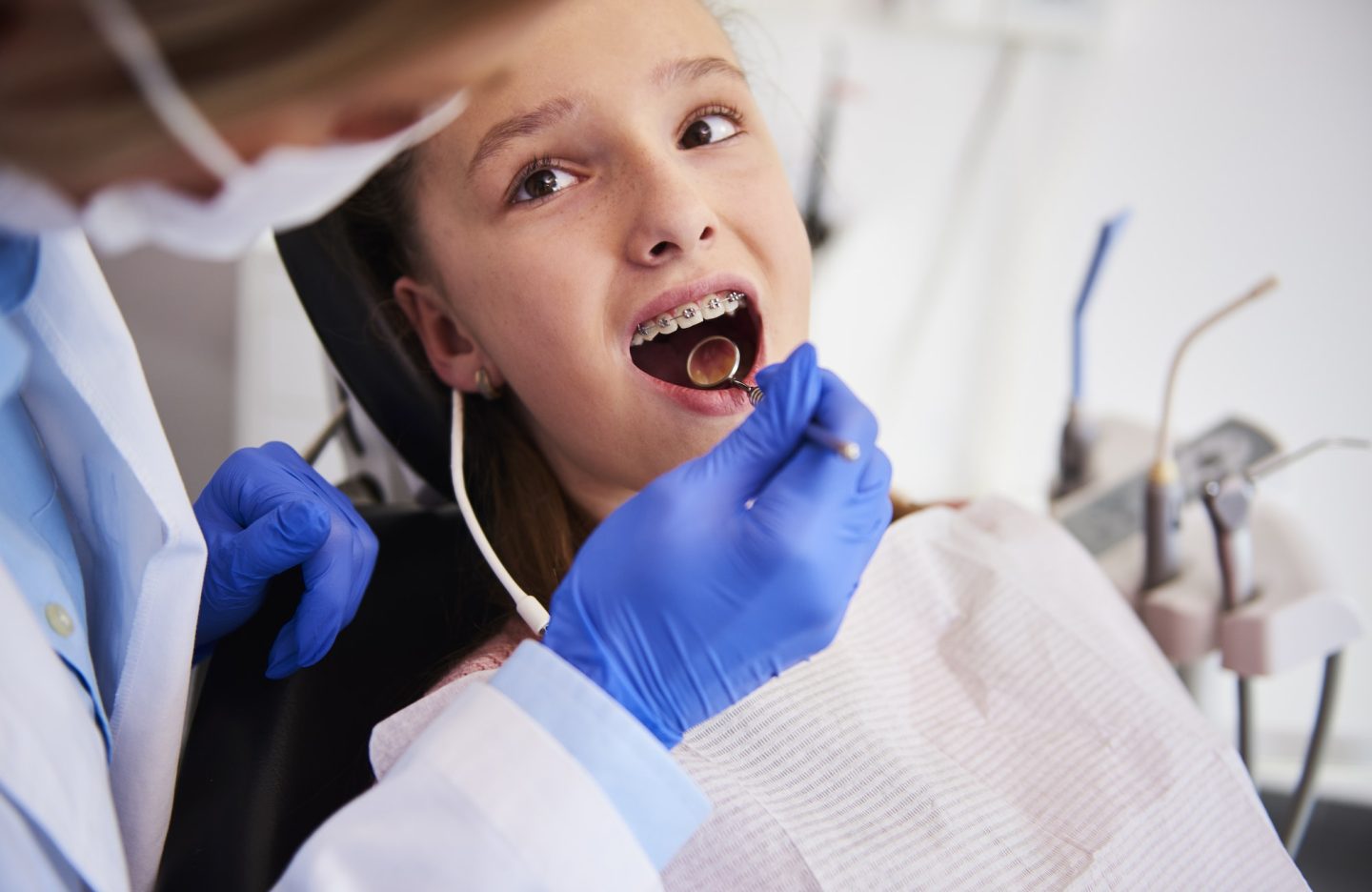 Part of orthodontist examining child's teeth in dentist's office
